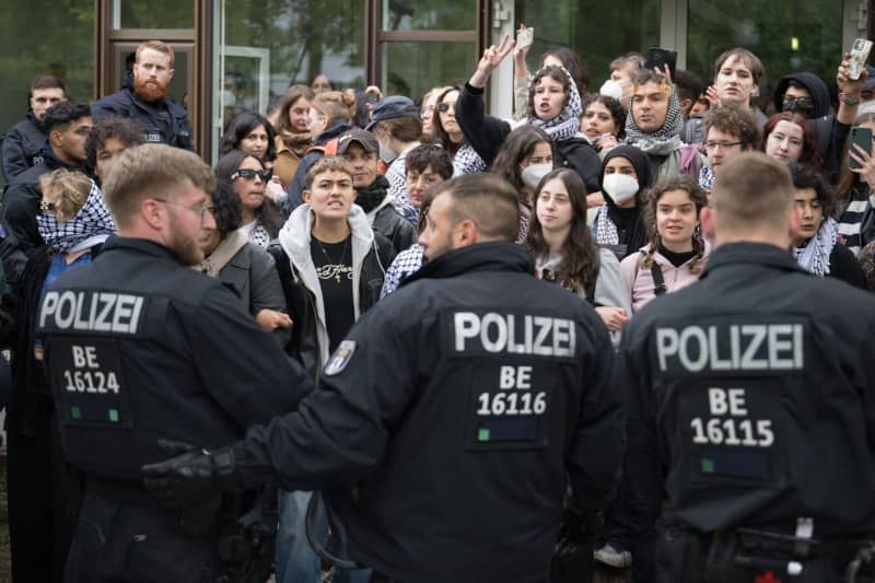 Participants stand in front of police officers during a pro-Palestinian demonstration by the "Student Coalition Berlin" group in the theater courtyard of the Free University of Berlin. The participants occupied the square with tents on Tuesday morning. Sebastian Christoph Gollnow/dpa