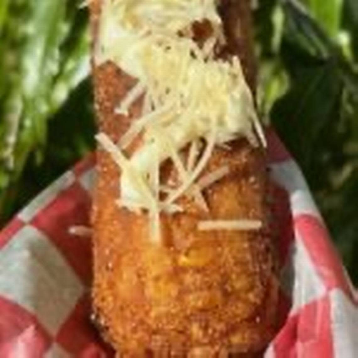 An image of deep fried corn on a stick.