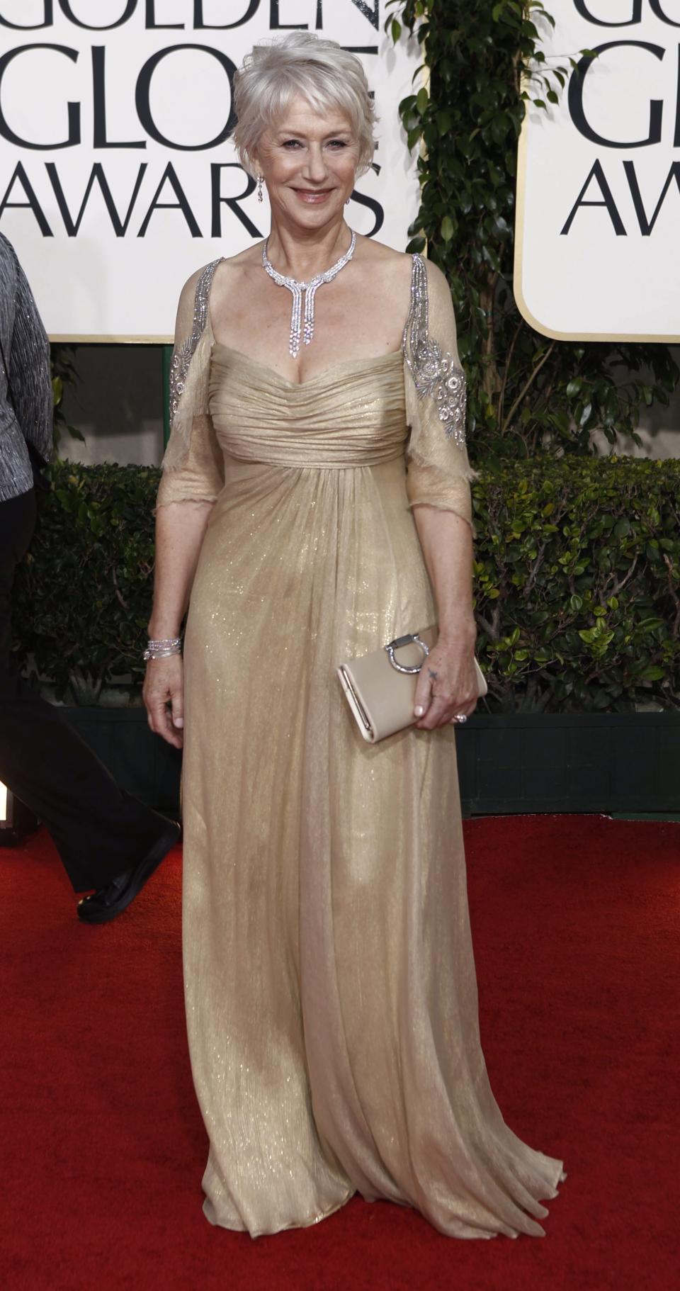 Helen Mirren poses in a gold Badgley Mischka Couture gown to the 2011 Golden Globe Awards. (Image via Getty Images)