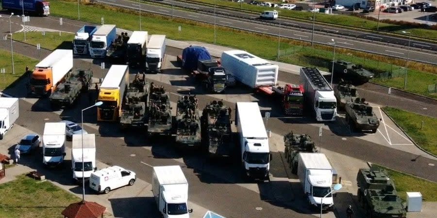 Polish military equipment next to trucks in a parking lot in Poland