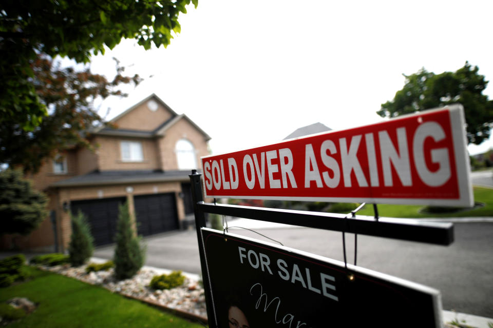 A real estate sign that reads “For Sale” and “Sold Above Asking” stands in front of housing in Vaughan, a suburb in Toronto, Canada, May 24, 2017. (REUTERS/Mark Blinch)