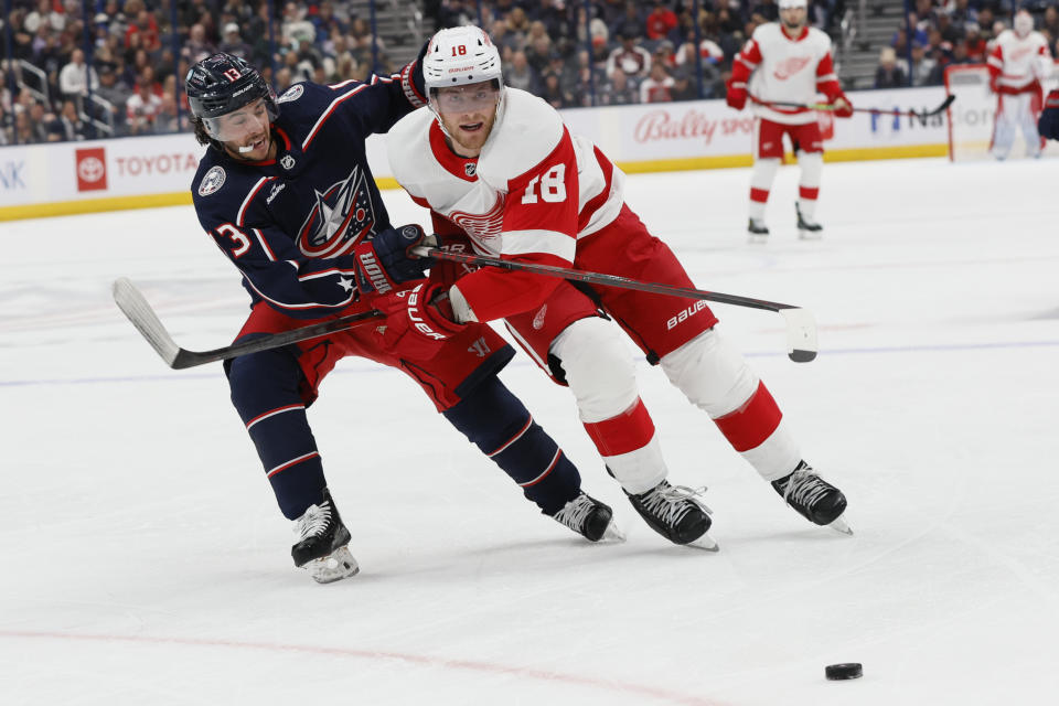 Detroit Red Wings' Andrew Copp, right, tries to skate past Columbus Blue Jackets' Johnny Gaudreau, left, during the first period of an NHL hockey game Monday, Oct. 16, 2023, in Columbus, Ohio. (AP Photo/Jay LaPrete)