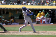 Texas Rangers' Marcus Semien, right, hits a grand slam in front of Oakland Athletics catcher Christian Bethancourt, left, during the fifth inning of a baseball game in Oakland, Calif., Saturday, May 28, 2022. (AP Photo/Jed Jacobsohn)