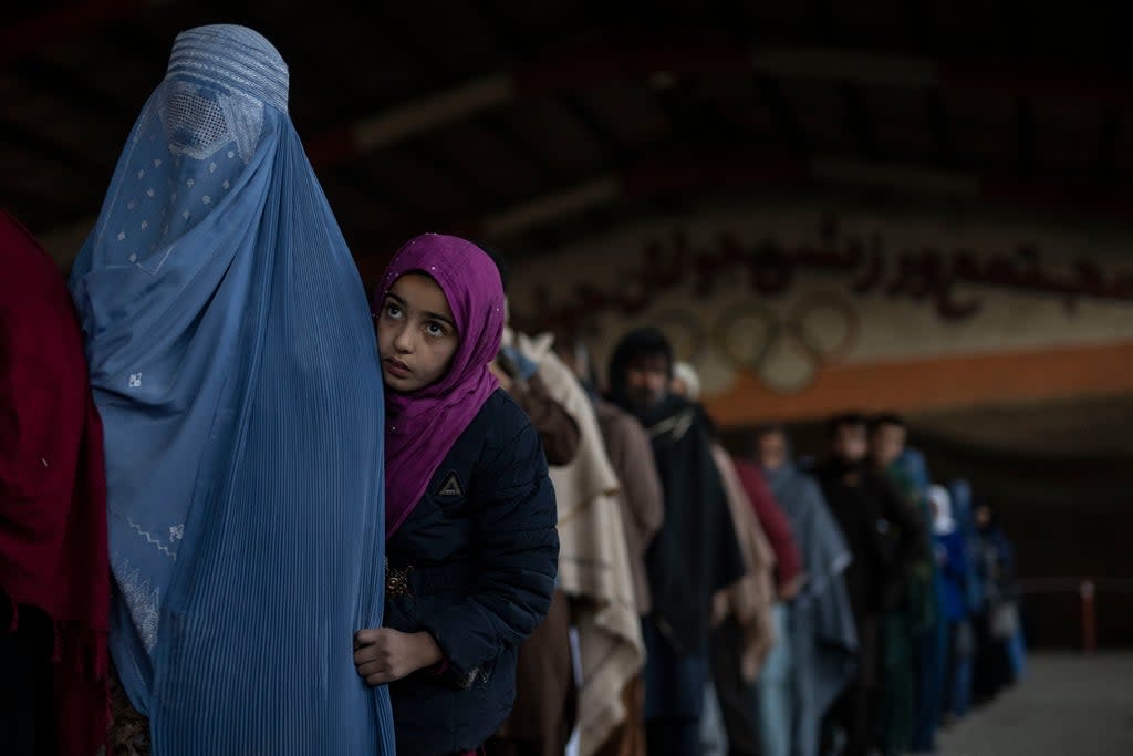 Women queue to receive cash at a site organized by the World Food Programme in Kabul, on 20 November 2021 (AP)