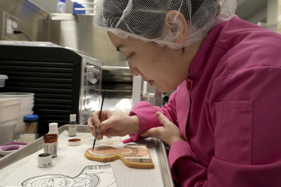 Jasmine Cho works on a cookie portrait of Filipina mambabatok tattoo artist Apo Whang-Od in Pittsburgh, Pa., Wednesday, May 3, 2023. Cho, a Korean American self-described “cookie activist,” has gained fans over the last several years for her finely detailed cookie mugs of famous and forgotten figures. (AP Photo/Matt Freed)