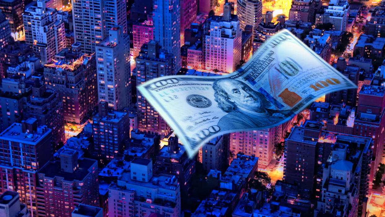  Conceptual image of American one hundred dollar bill flying across a city nightscape 