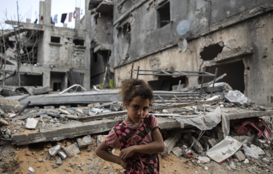 Palestinian Rahaf Nuseir, 10, looks on as she stands in front of her family's destroyed homes, to which they returned following a cease-fire reached after an 11-day war between Gaza's Hamas rulers and Israel, in town of Beit Hanoun, northern Gaza Strip, Friday, May 21, 2021. (AP Photo/Khalil Hamra)