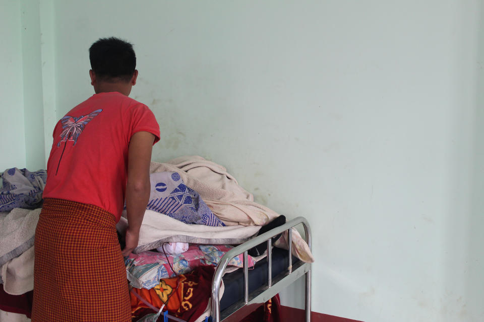 A member of the Chin National Army tends to a 19-year-old comrade whose leg was amputated the night before, in August, after he stepped on a landmine. The amputation was conducted by medical volunteers at an abandoned government hospital now run by the public administration of the Chinland Defense Forces-Thantlang.<span class="copyright">Emily Fishbein</span>