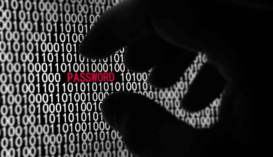 A shadowy hand reaches for the word 'PASSWORD' displayed on a computer screen.