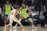 Atlanta Hawks guard Trae Young (11) dribbles the ball in front of Minnesota Timberwolves center Karl-Anthony Towns (32) during the second half of an NBA basketball game Wednesday, Jan. 19, 2022, in Atlanta. (AP Photo/Hakim Wright Sr.)