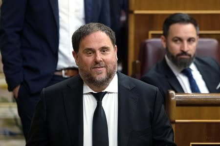 FILE PHOTO: Jailed Catalan politician Oriol Junqueras walks past Santiago Abascal, leader of far-right party VOX, during the first session of parliament following a general election in Madrid