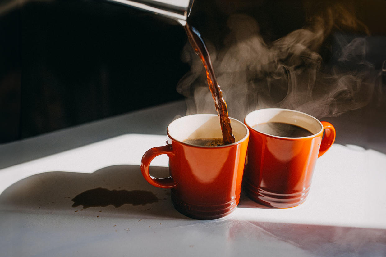 Coffee Pouring in Two Mugs Getty Images/Stefania Pelfini, La Waziya Photography