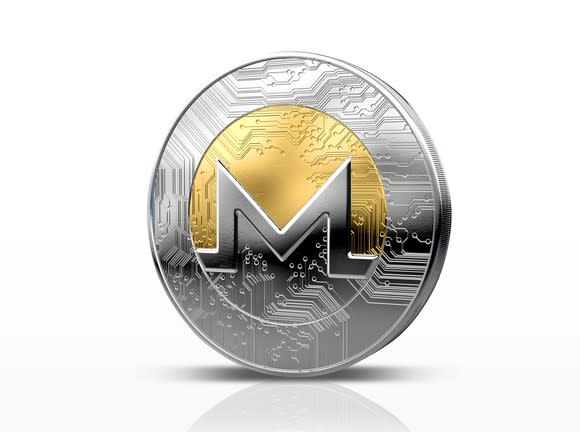 A physical silver and gold Monero coin.