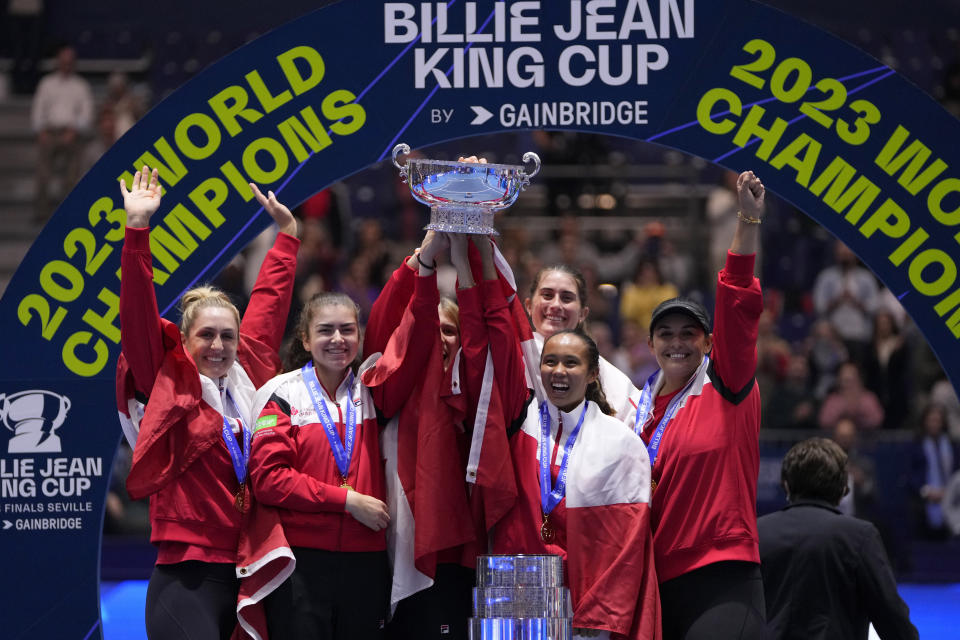 Canada's Leylah Fernandez, right, lifts the trophy with members of her team after wining the final singles tennis match against Italy's Jasmine Paolini, during the Billie Jean King Cup finals in La Cartuja stadium in Seville, southern Spain, Spain, Sunday, Nov. 12, 2023. (AP Photo/Manu Fernandez)