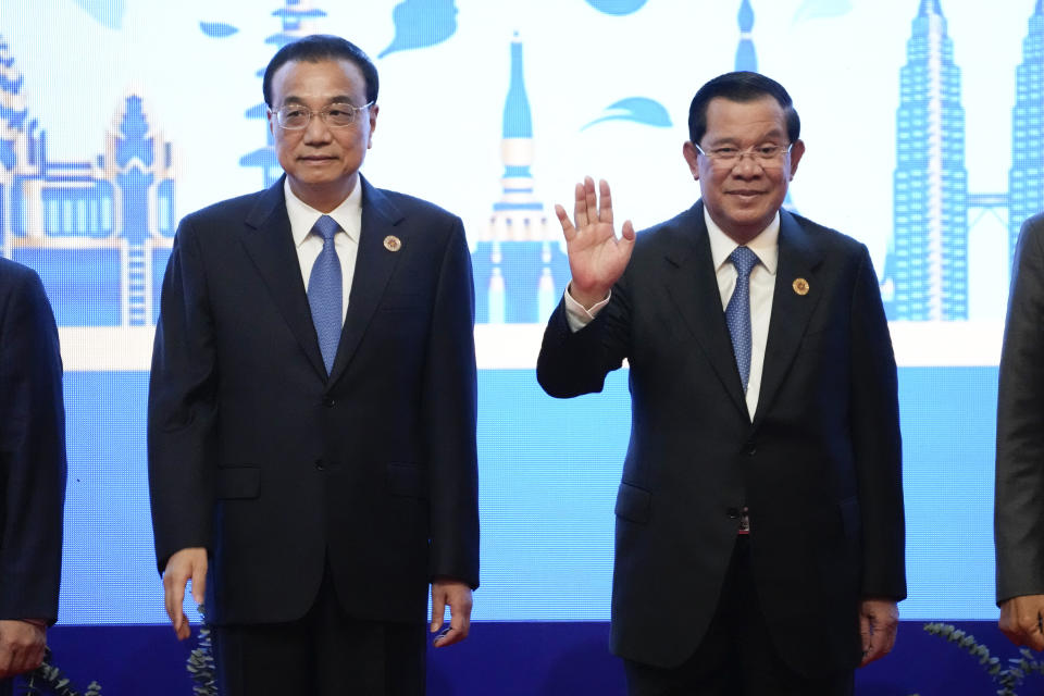 Cambodia Prime Minister Hun Sen waves as China's Premier Li Keqiang stand next to him during group photo of the ASEAN - China Summits (Association of Southeast Asian Nations) in Phnom Penh, Cambodia, Friday, Nov. 11, 2022. Association of Southeast Asian Nations leaders struggled Friday to come to a consensus on how to pressure Myanmar to comply with a plan for peace, with violence in the member state spiraling out of control since the military seized power in 2021. (AP Photo/Heng Sinith)
