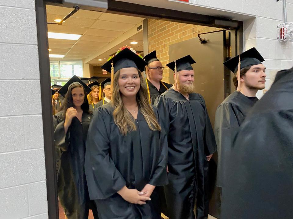 North Central State College graduates smile proudly as they march into the OSUM/NCSC Recreation Center Friday night for commencement.