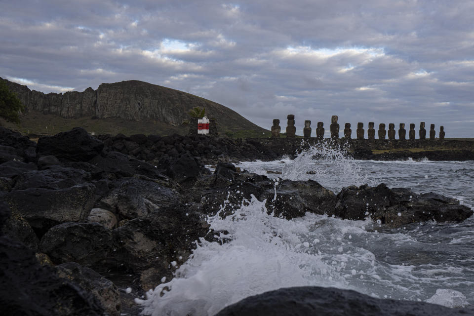 The sea hits the rocks of a fishermen's cove near Ahu Tongariki and Rano Raraku volcano, behind, on Rapa Nui, or Easter Island, Chile, Tuesday, Nov. 22, 2022. Each monolithic human figure carved centuries ago by this remote Pacific island's Rapanui people represent an ancestor. (AP Photo/Esteban Felix)