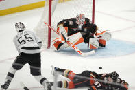 Anaheim Ducks goaltender Lukas Dostal, upper right, stops a shot by Los Angeles Kings right wing Quinton Byfield, left, as defenseman William Lagesson defends during the third period of an NHL hockey game Saturday, April 13, 2024, in Los Angeles. (AP Photo/Mark J. Terrill)