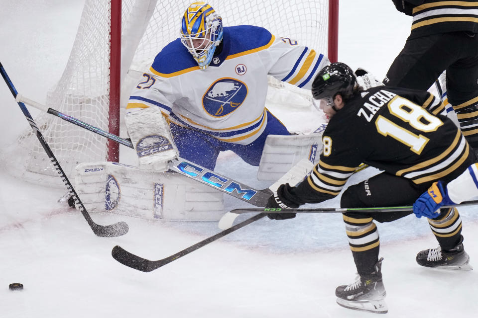 Buffalo Sabres goaltender Devon Levi (27) deflects the puck as Boston Bruins center Pavel Zacha (18) attempts to score during the second period of an NHL hockey game Thursday, Dec. 7, 2023, in Boston. (AP Photo/Steven Senne)