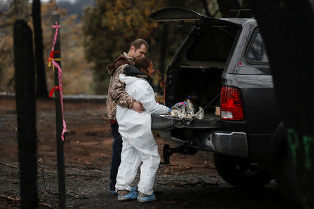 Brett Bizzle comforts his wife Vanthy Bizzle who became emotional after returning to the remains of their home for the first time since the Camp Fire forced them to evacuate in Paradise, California, U.S. November 22, 2018. REUTERS/Elijah Nouvelage