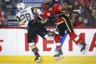 Vegas Golden Knights' William Carrier, left, is checked by Calgary Flames' Zac Rinaldo during the first period of an NHL hockey game, Sunday, March 8, 2020, in Calgary, Alberta. (Jeff McIntosh/The Canadian Press via AP)