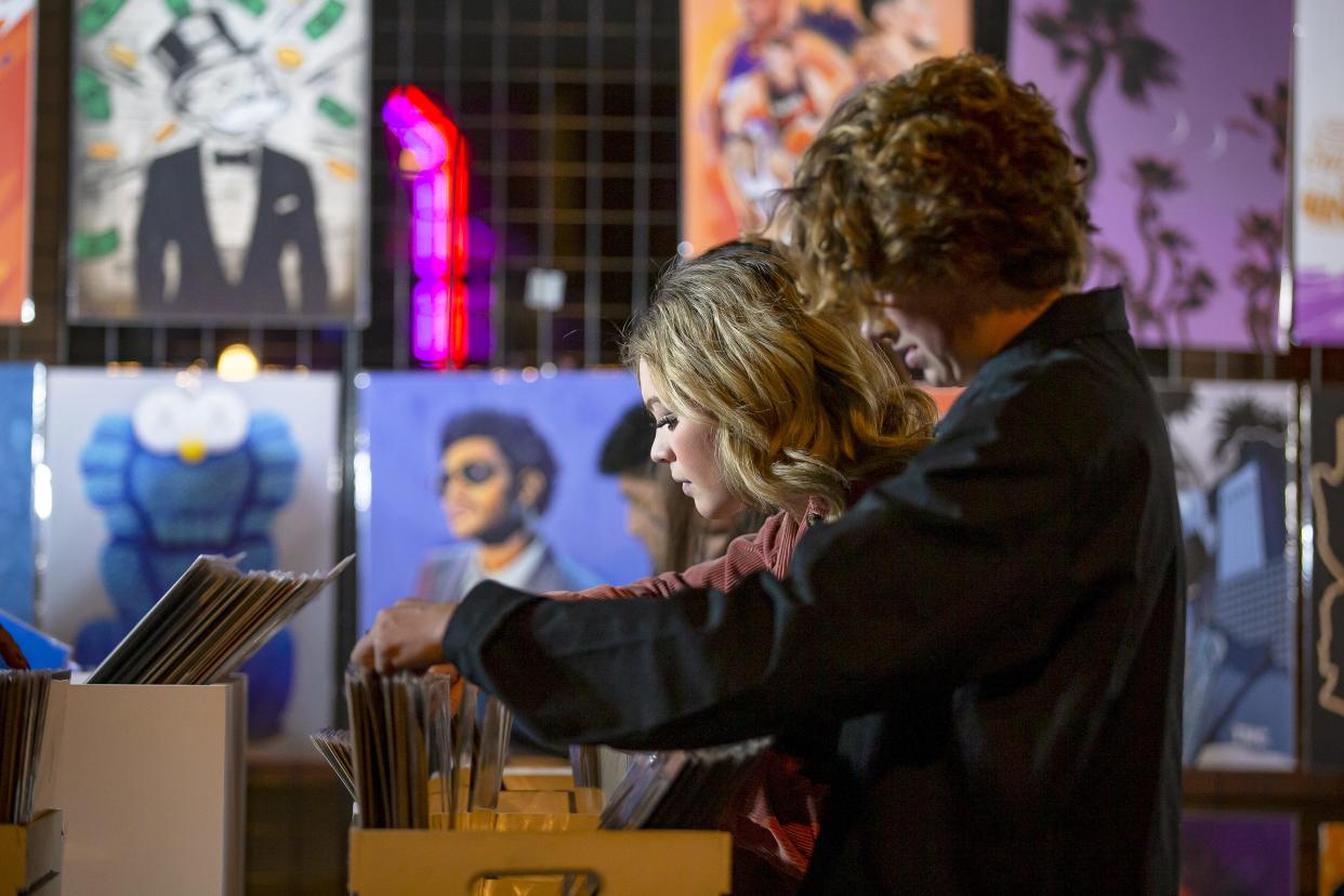 Tabitha Bland and Matt Baker browse through crates of vinyl records at a booth on Second and Roosevelt streets during the First Friday Art Walk in Phoenix on Mar. 4, 2022.