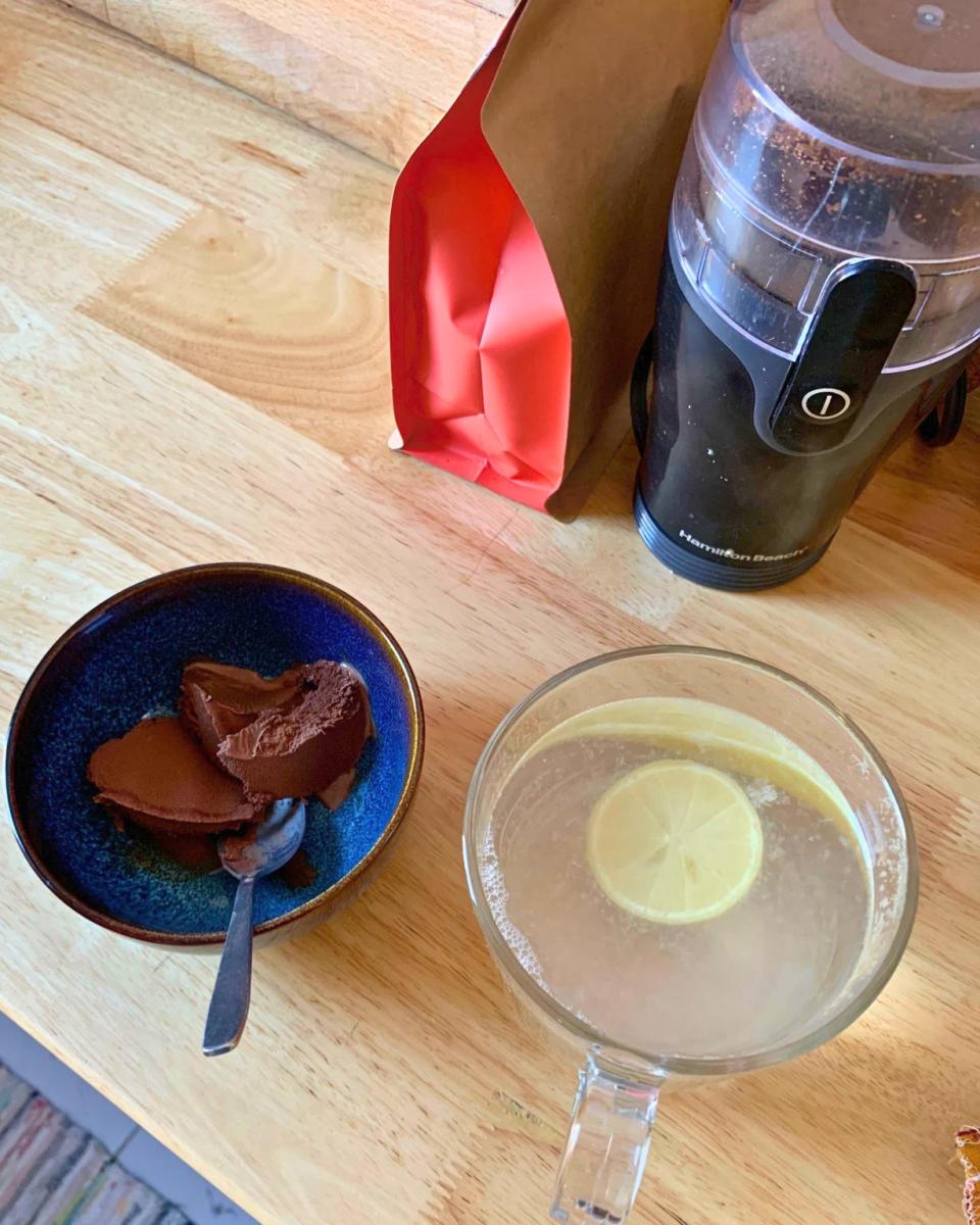 Hot water and lemon, with a coffee grinder and coffee seen above.