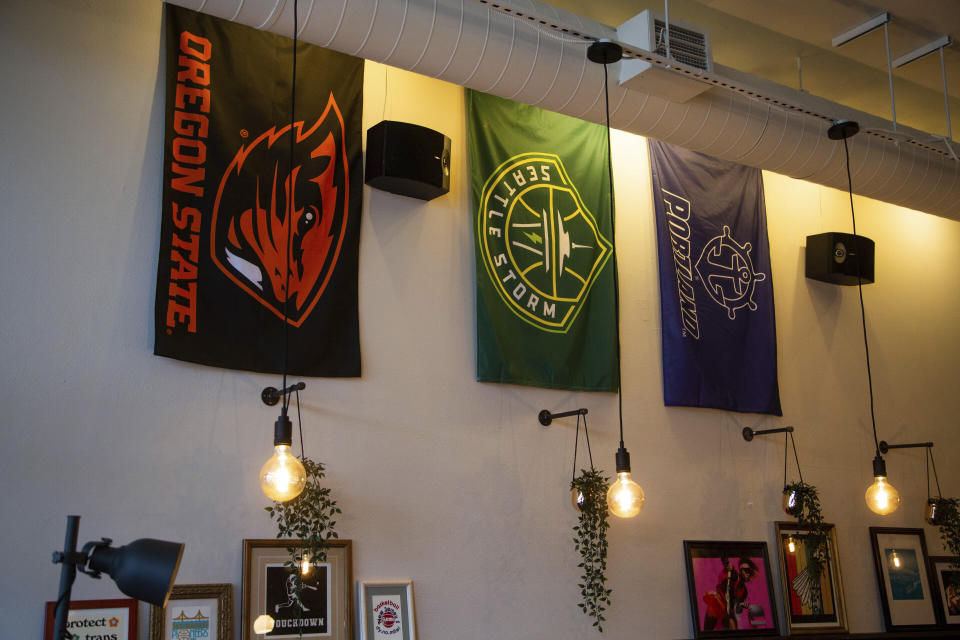 Team flags for Oregon State, Seattle Storm and University of Portland hang on the wall of The Sports Bra, a bar and restaurant dedicated to women's sports, on Monday, Feb. 22, 2022. (Vickie Connor/The Oregonian via AP)