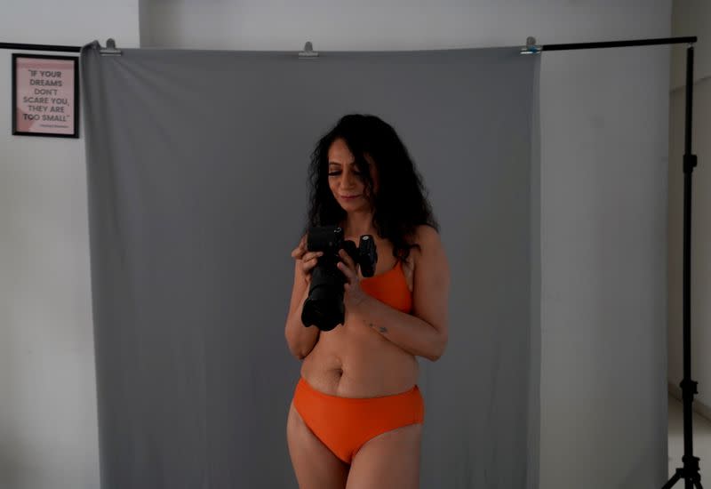 Geeta J looks at her photos in a camera during her lingerie photoshoot inside a studio in Mumbai