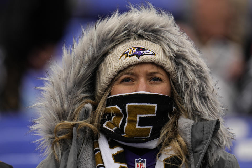A Baltimore Ravens fan watches teams warm up before an NFL football AFC divisional playoff game between the Baltimore Ravens and the Houston Texans, Saturday, Jan. 20, 2024, in Baltimore. (AP Photo/Julio Cortez)