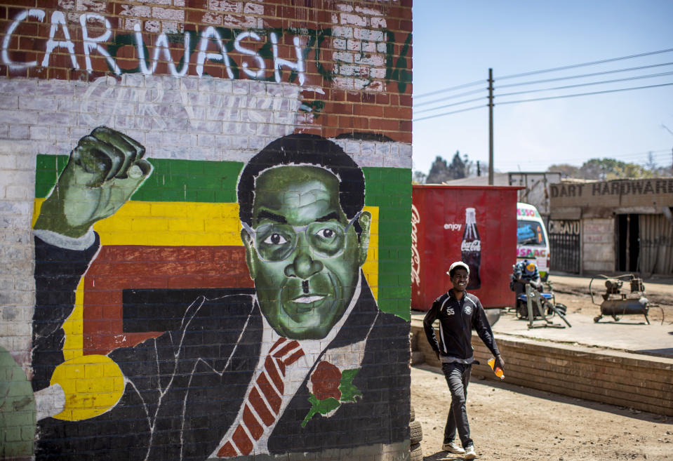 A man walks past a mural of former president Robert Mugabe, in the low income neighbourhood of Mbare, known to have many supporters of Mugabe's ZANU-PF party, in the capital Harare, Zimbabwe Monday, Sept. 9, 2019. Mugabe, who enjoyed strong backing from Zimbabwe's people after taking over in 1980, but whose support waned following decades of repression, economic mismanagement and allegations of election-rigging, is expected to be buried on Sunday, state media reported. (AP Photo/Ben Curtis)