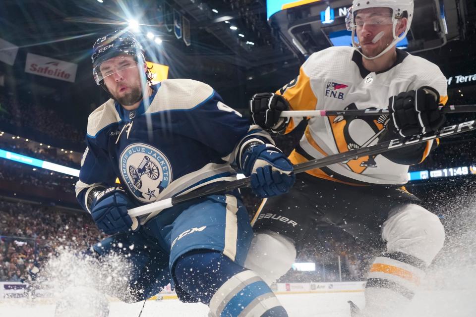 Mar 30, 2024; Columbus, Ohio, USA; Columbus Blue Jackets defenseman Ivan Provorov (9) fights for a puck with Pittsburgh Penguins left wing Michael Bunting (8) in the second period of the NHL hockey game at Nationwide Arena.