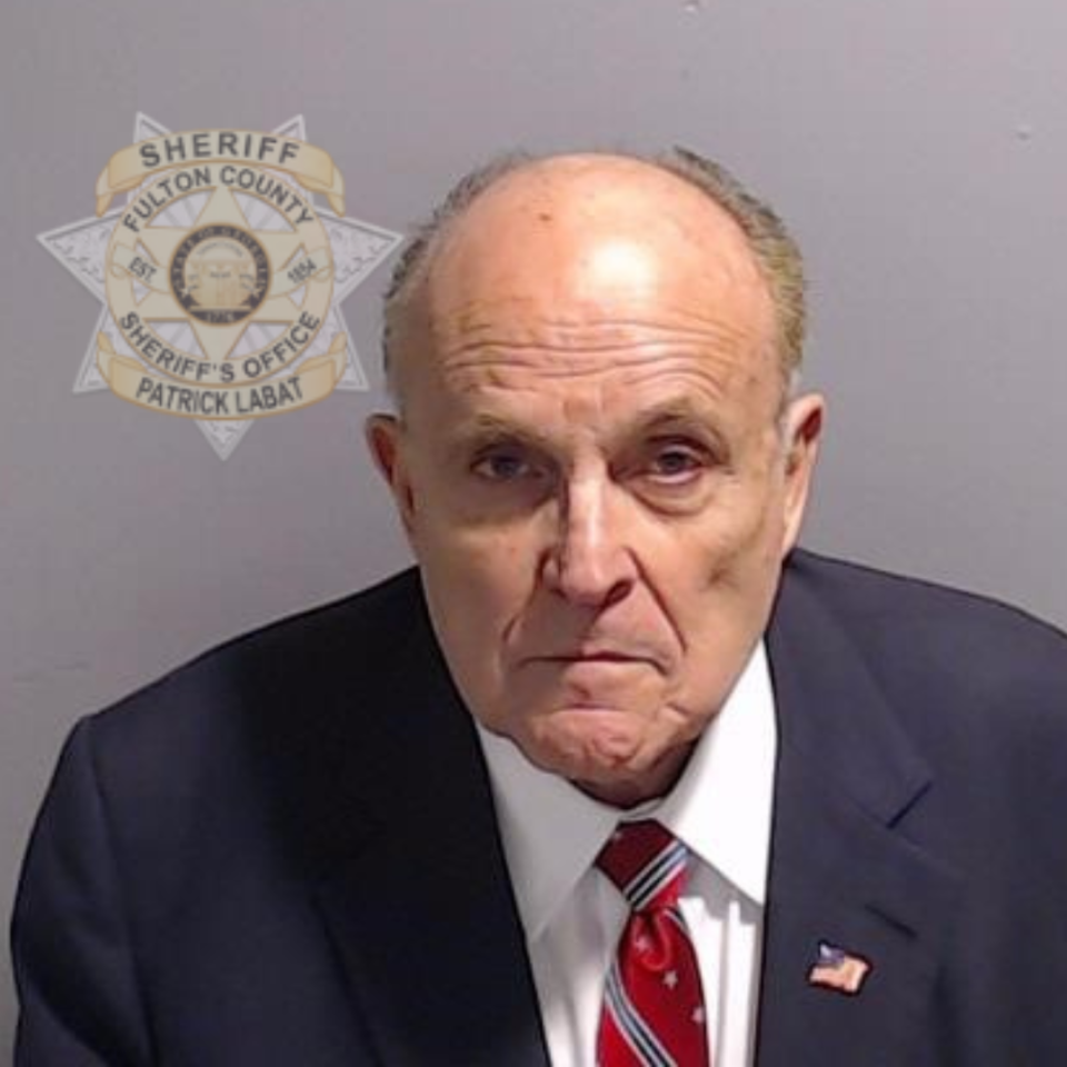 Rudy Giuliani in front of a badge saying Sheriff, Fulton County Sheriff's Office, Patrick Labat.