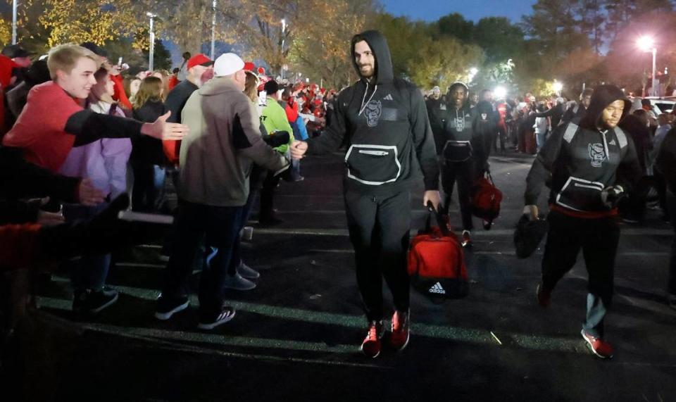 N.C. State linebacker Payton Wilson (11) greets fans during the Walk of Champions before N.C. State’s game against UNC at Carter-Finley Stadium in Raleigh, N.C., Saturday, Nov. 25, 2023.