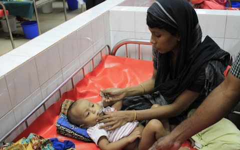 One-month old baby Alif and his mother Eihna, who is spoon feeding him oral rehydration solution at the International Centre for Diarrhoeal Disease Research, Bangladesh - Credit: Susannah Savage