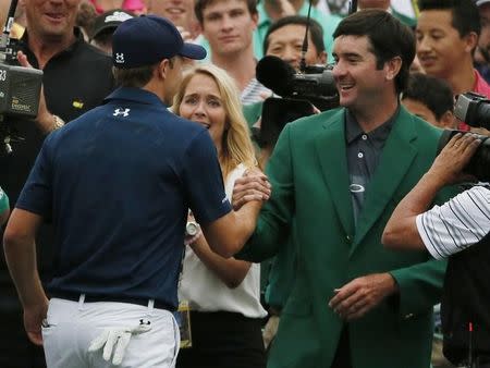 Jordan Spieth of the U.S. (L) shakes hands with last year's champion Bubba Watson after winning the Masters golf tournament at the Augusta National Golf Course in Augusta, Georgia April 12, 2015. REUTERS/Phil Noble