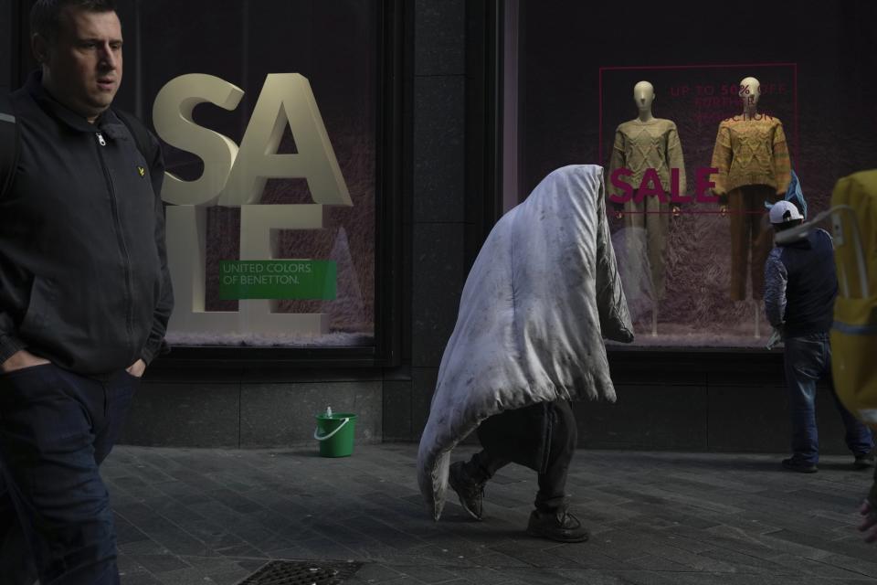 FILE - A homeless man walks along a street in a shopping district in central London, on Feb. 2, 2023. The British economy stagnated in the final three months of last year as the country struggled under the weight of a cost-of-living crisis that is squeezing household budgets, crimping business investment and fueling labor unrest. The Office for National Statistics said Friday, Feb. 10, 2023, that gross domestic product, the broadest measure of economic activity, failed to grow during the fourth quarter of 2022. (AP Photo/Kin Cheung)