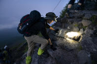 Un hombre escala en plena madrugada con el objetivo de ver el amanecer en la cumbre. <br><br>Foto: AP Photo/Jae C. Hong