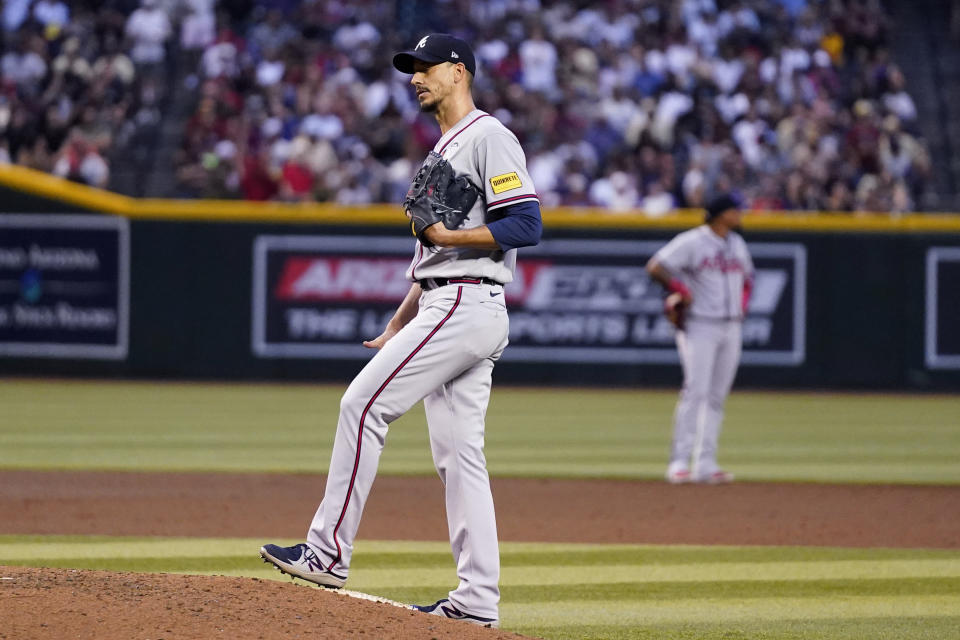 Atlanta Braves starting pitcher Charlie Morton, foreground, pauses on the mound after giving up a run-scoring double to Arizona Diamondbacks' Christian Walker during the third inning of a baseball game Friday, June 2, 2023, in Phoenix. (AP Photo/Ross D. Franklin)