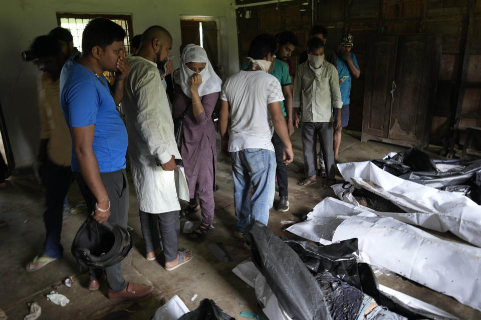 People try to identify their relatives who was traveling in the train that derailed in Balasore district, in the eastern Indian state of Orissa, Sunday, June 4, 2023. Indian authorities end rescue work and begin clearing mangled wreckage of two passenger trains that derailed in eastern India, killing over 300 people and injuring hundreds in one of the country’s deadliest rail crashes in decades. (AP Photo/Rafiq Maqbool)