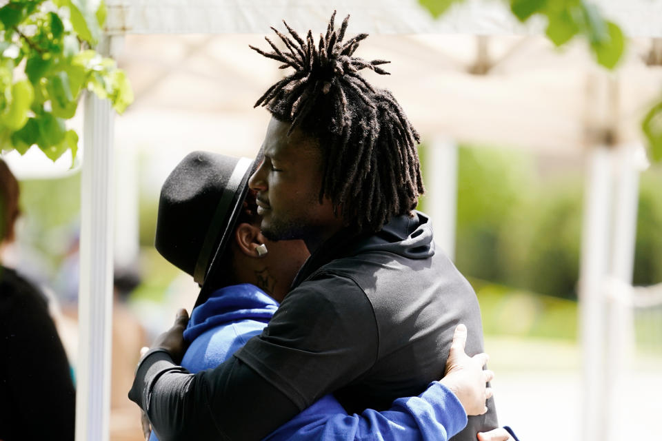 Buffalo Bills' Josh Thomas, right, embraces a person as he visits the scene of Saturday's shooting at a supermarket, in Buffalo, N.Y., Wednesday, May 18, 2022. (AP Photo/Matt Rourke)