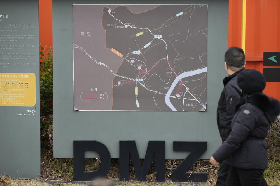 Visitors walk past near a map of the Demilitarized Zone (DMZ) at the Imjingak Pavilion in Paju, South Korea, Wednesday, Nov. 22, 2023. South Korea will partially suspend an inter-Korean agreement Wednesday to restart frontline aerial surveillance of North Korea, after the North said it launched a military spy satellite in violation of United Nations bans, Seoul officials said. (AP Photo/Lee Jin-man)