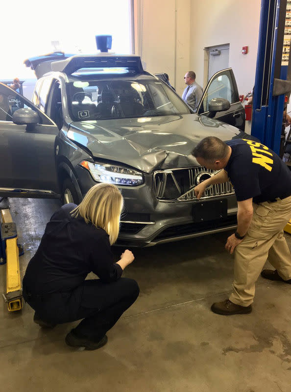 National Transportation Safety Board (NTSB) investigators examine a self-driving Uber vehicle involved in a fatal accident in Tempe, Arizona, U.S., March 20, 2018. National Transportation Safety Board/Handout via REUTERS