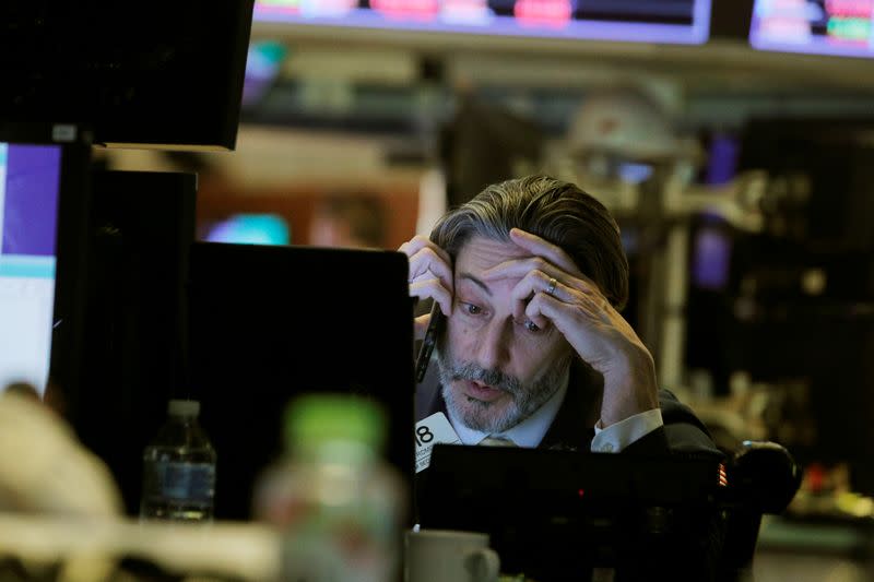 A trader talks on the phone while working on the floor of the New York Stock Exchange (NYSE) in New York