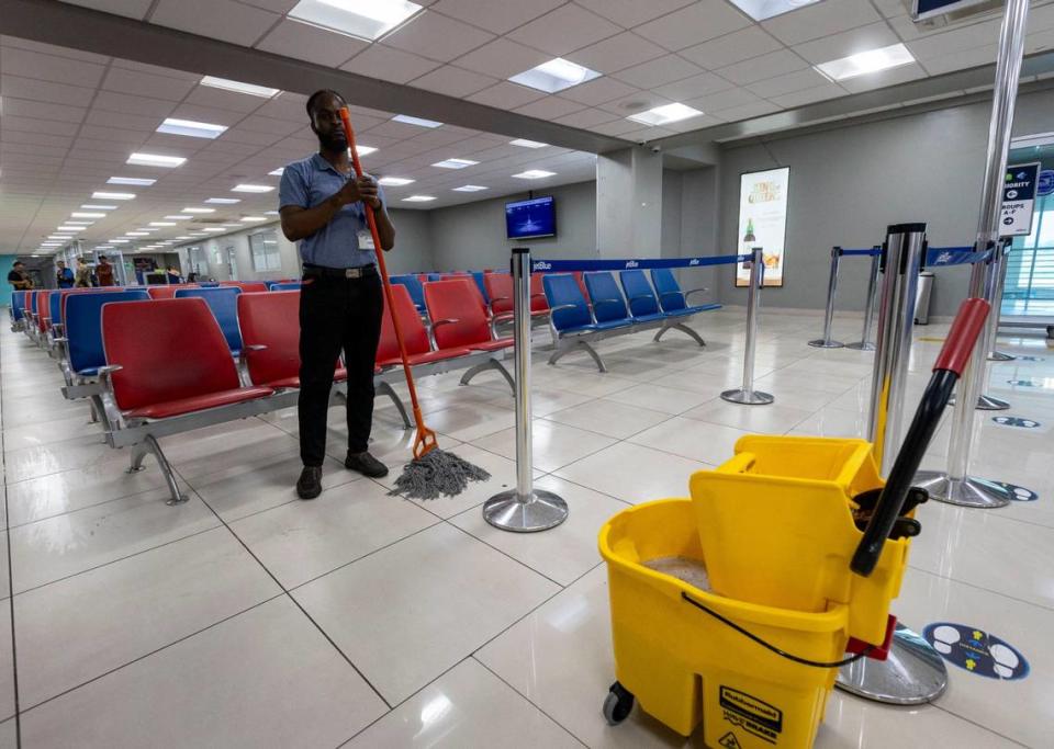 A Haitian airport worker pauses Wednesday, May 15, 2024 as he mops the floor in an empty main terminal at Toussaint Louverture International Airport in Port-au-Prince, Haiti.