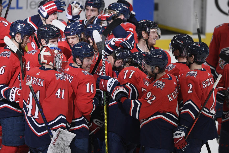 Washington Capitals left wing Jakub Vrana (13) is mobbed by teammates after his overtime goal against the New Jersey Devils in an NHL hockey game Tuesday, March 9, 2021, in Washington. The Capitals won 5-4. (AP Photo/Nick Wass)