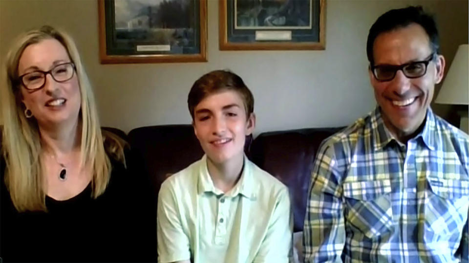 In this still image, taken from video by the Office of the Ohio Governor, eighth grader Joseph Costello, center, of Englewood, Ohio, the winner of the Ohio Vax-a-Million, full college scholarship vaccination incentive prize, is interviewed during a news conference, Thursday, May 27, 2021. He is joined by his parents Colleen and Rich Costello. (Office of Ohio Governor via AP)