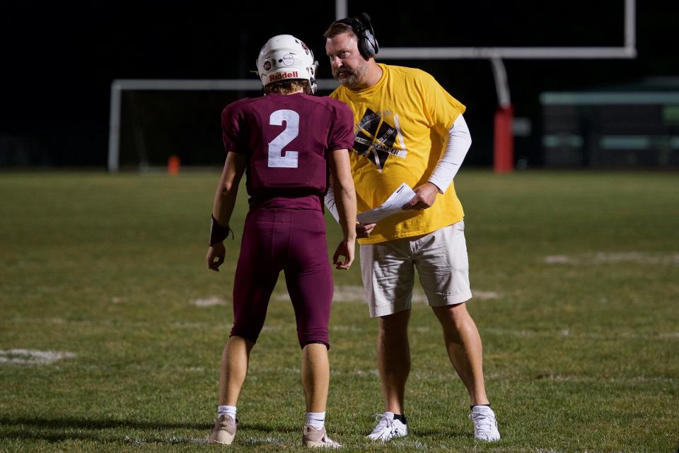 Abington head coach Kevin Conlin talks to quarterback Johnny Dzielawa during a 2021 game.