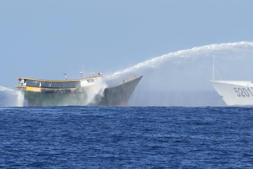 Philippine resupply vessel Unaizah May 4, left, is hit by two Chinese coast guard water canons as they tried to enter the Second Thomas Shoal, locally known as Ayungin Shoal, in the disputed South China Sea Tuesday, March 5, 2024. Chinese and Philippine coast guard vessels collided in the disputed South China Sea and four Filipino crew members were injured in high-seas confrontations Tuesday as Southeast Asian leaders gathered for a summit that was expected to touch on Beijing's aggression at sea. (AP Photo/Aaron Favila)