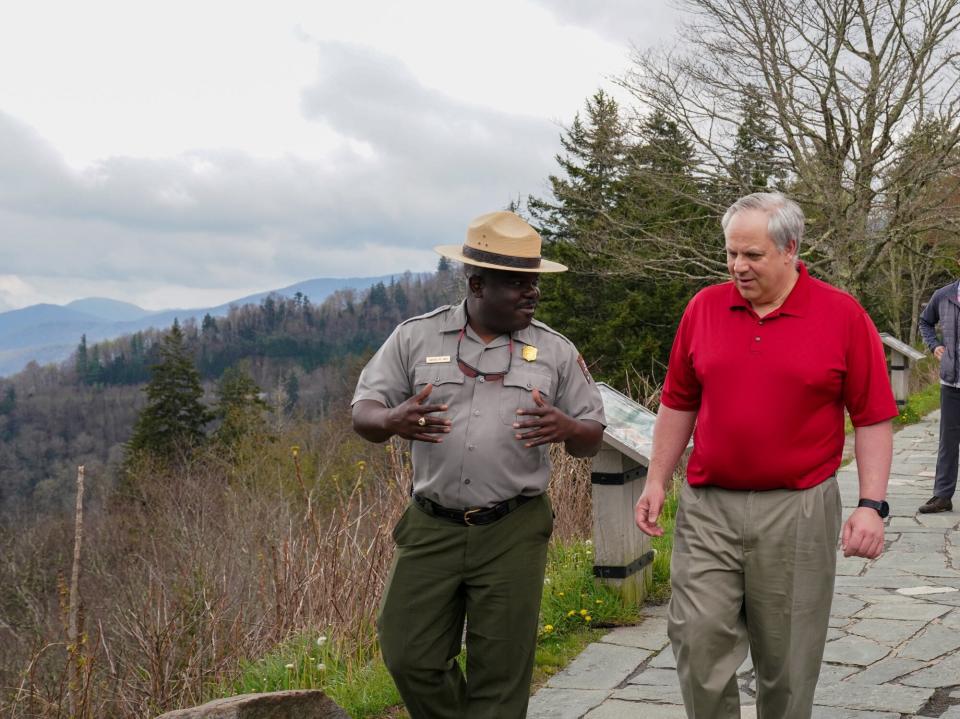 This Wednesday, May 6, 2020 image from a tweet by Interior Secretary David Bernhardt, the Interior Secretary visits with National Parks Service employees at Great Smoky Mountains National Park. While the Interior Secretary asked visitors to social distance when the park reopens on May 9, neither Bernhardt nor park staff wore face masks in the photos, as they talked and walked inches apart during his visit on Tuesday, May 5. (National Parks Service via AP)